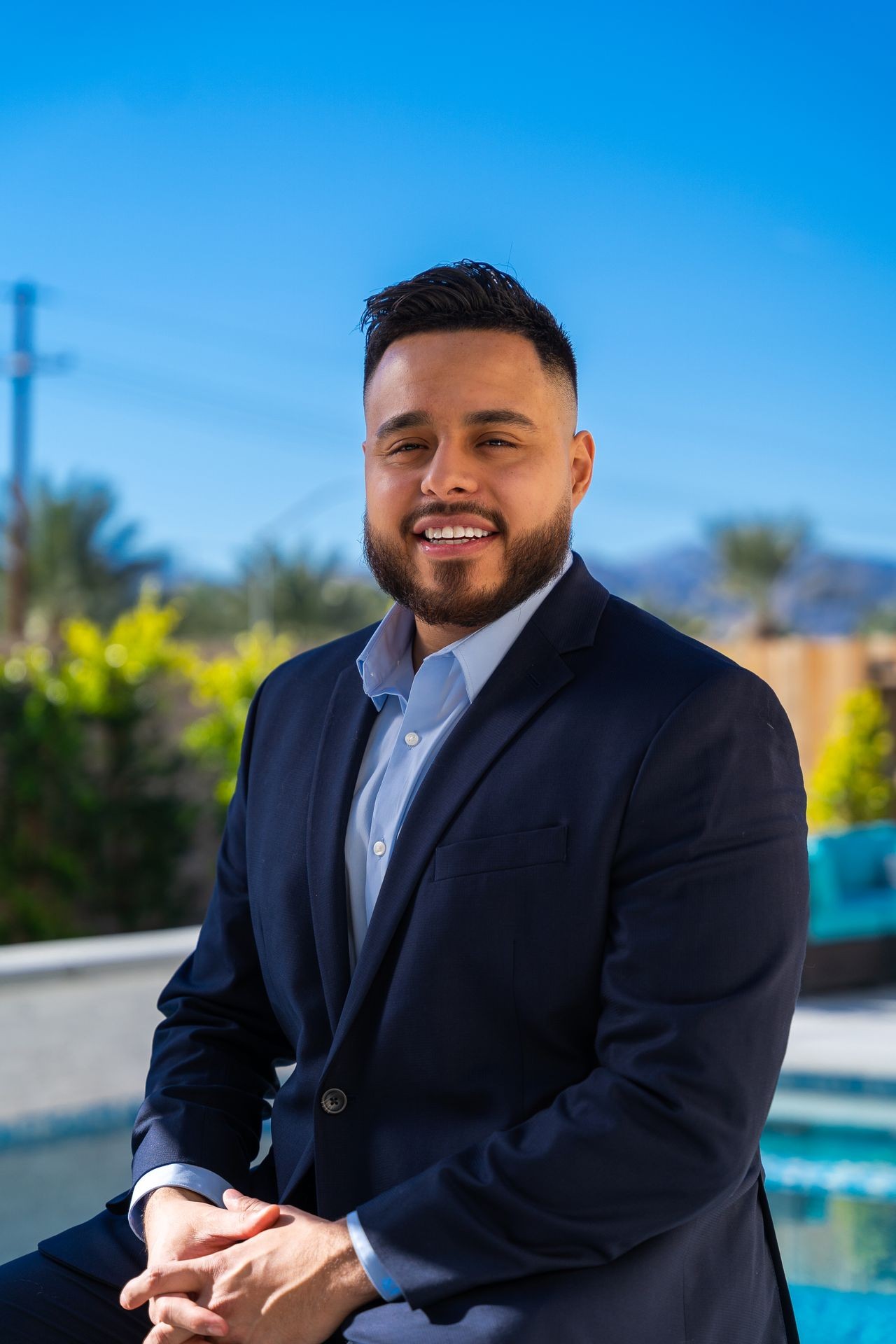 Headshot of IMAGESTATE owner by pool with mountains in the background